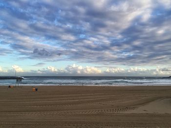 Scenic view of beach and sea against cloudy sky