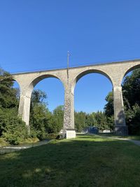 Arch bridge against clear blue sky