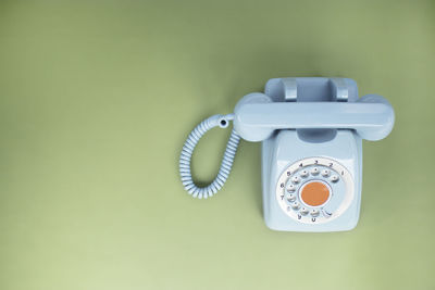 Close-up of telephone booth against wall