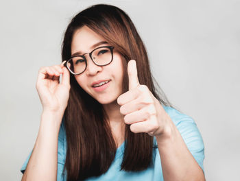 Portrait of smiling young woman against white background