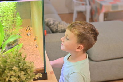 Side view of girl looking through window