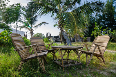 Chairs and table by trees against sky