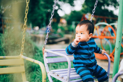 Cute boy looking away on swing