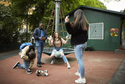 Cheerful females gesturing while winning robot battle against male friends