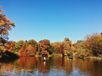 Scenic view of lake by trees against clear sky