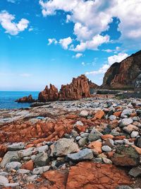 Scenic view of rocks on beach against sky