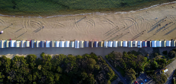 High angle view of trees and beach huts on sand at beach