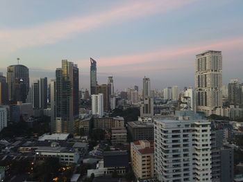 Modern buildings in city against sky during sunset