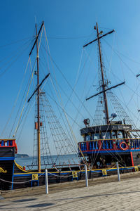 Sailboats moored in sea against clear sky
