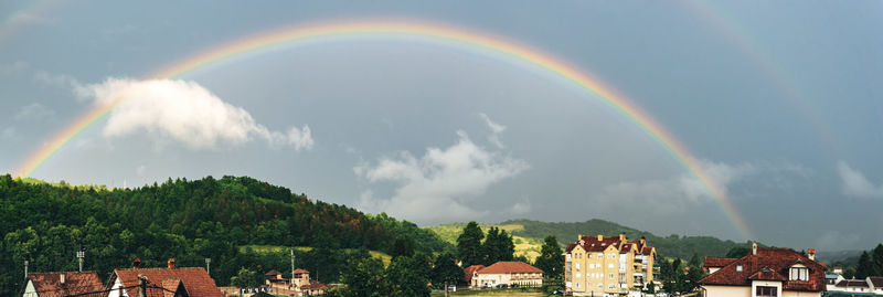 Panoramic view of rainbow over buildings in city