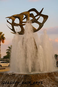 Water splashing on fountain against sky