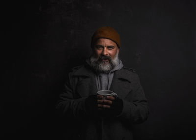 Beggar man smiling, happy even living on the street. cheerful homeless man with cup of hot tea