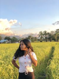 Side view of woman standing on field against sky