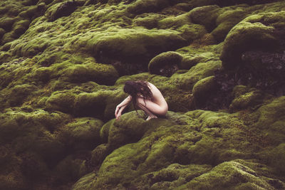Side view of woman relaxing on moss