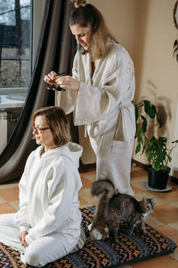 Side view of mother and daughter sitting at home