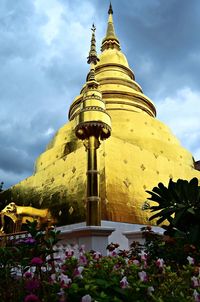 Low angle view of golden stupa against sky