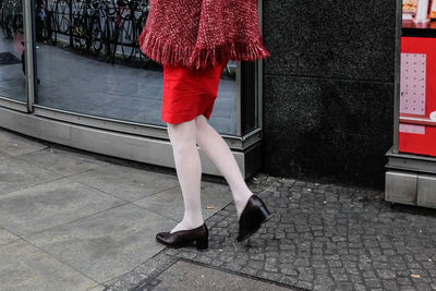 Low section of woman walking on footpath