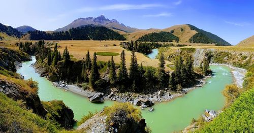 Scenic view of river and mountains against sky