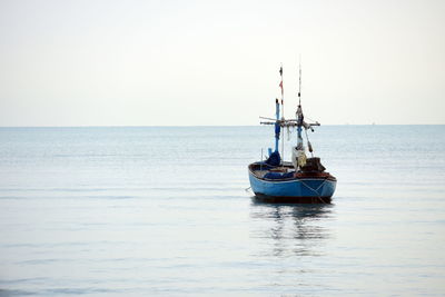 Sailboat in sea against clear sky