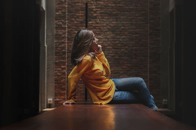 Woman sitting on wall at home