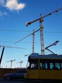 Low angle view of crane against blue sky