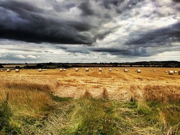 Scenic view of field against cloudy sky