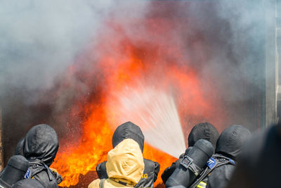 Rear view of firefighters extinguishing fire