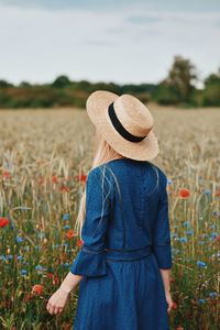 Rear view of woman standing in field