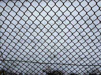 Full frame shot of chainlink fence against sky