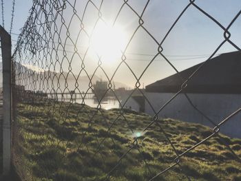 Fence on field against sky during sunset