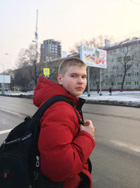 Side view of boy in city during winter