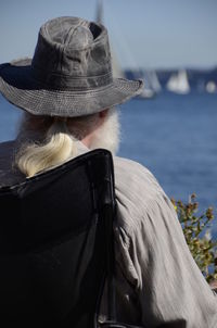 Rear view of woman wearing hat against sea