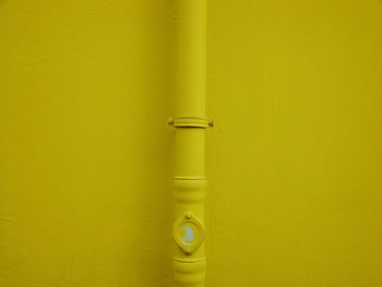 Close-up of pipe on yellow wall