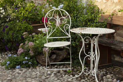 High angle view of a romantic white table and chair in metall near potete plants and floweris