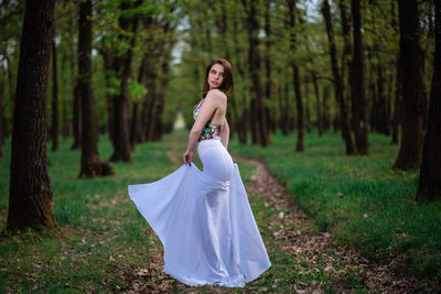 Woman standing on field in forest