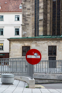 Road sign against buildings in city