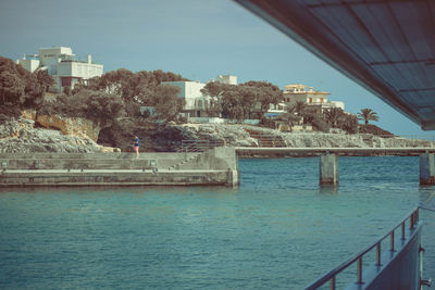 Buildings by sea against sky in city