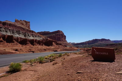 Scenic view of desert against clear blue sky