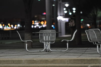 Empty seats on table in city at night