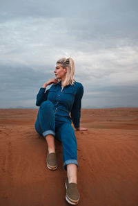 Full length of woman standing on beach against sky