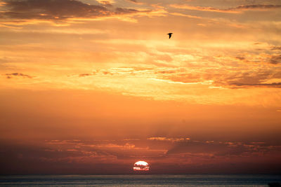 Scenic view of sea against orange sky