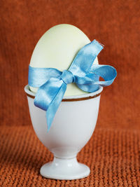 Close-up of blue tied bow ribbon on easter egg on table