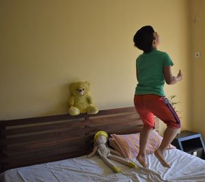 Boy with toy on bed at home