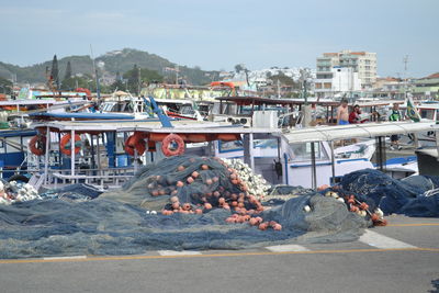 People at harbor against sky in city