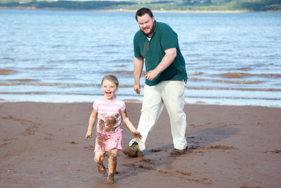 Daughter playing with father at beach