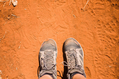 Low section of man standing on dirt road