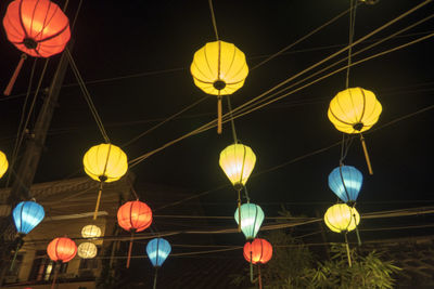Low angle view of illuminated lanterns hanging at night