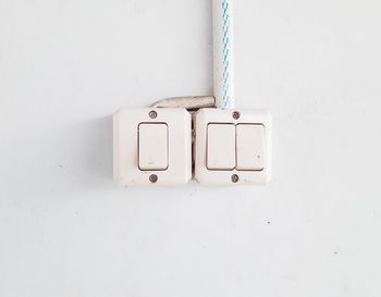 Close-up of electric lamp against white wall at home