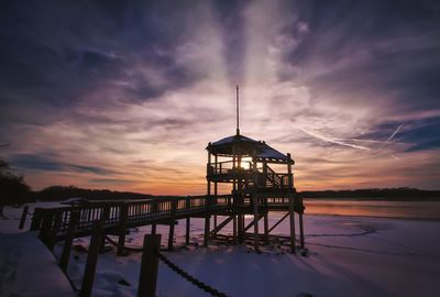 Gazebo at beach against sky during sunset