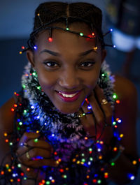 Portrait of a smiling young woman with christmas lights 